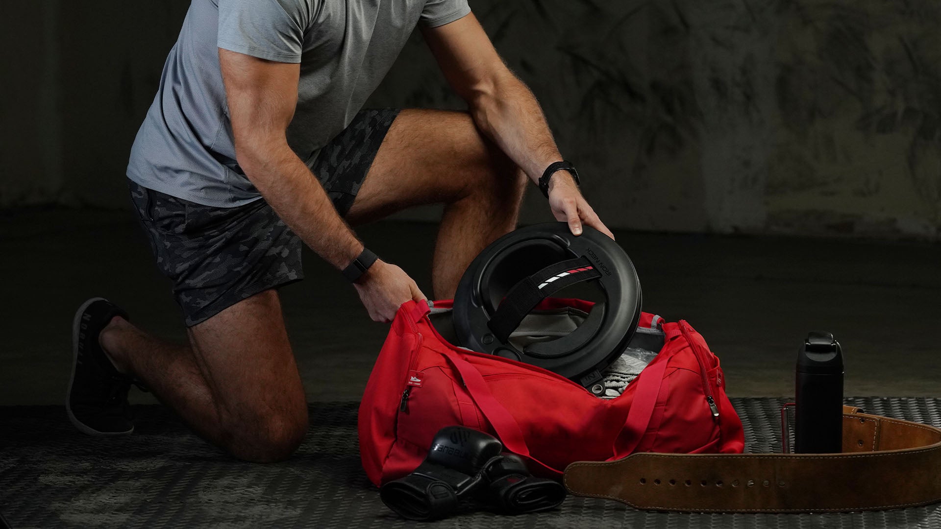 Man putting Iron Neck in thier gym bag